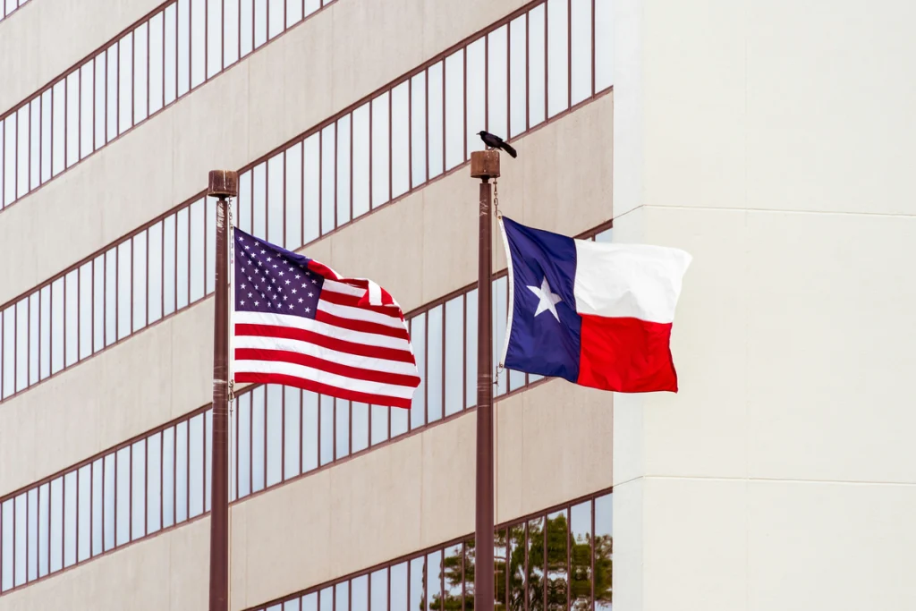A Texas flag and a US flag are flying in front of an office building, where bookkeeping and taxes in Killeen TX are dealt with by accountants.